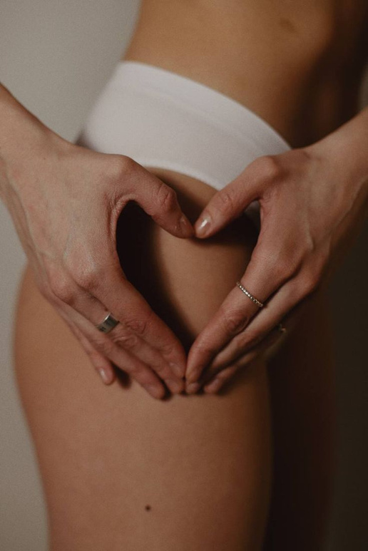 Hands forming a heart over the lower back