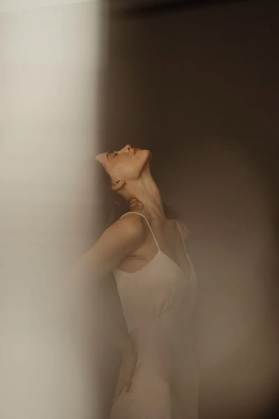 Woman opening her chest and breathing deeply in soft, atmospheric light